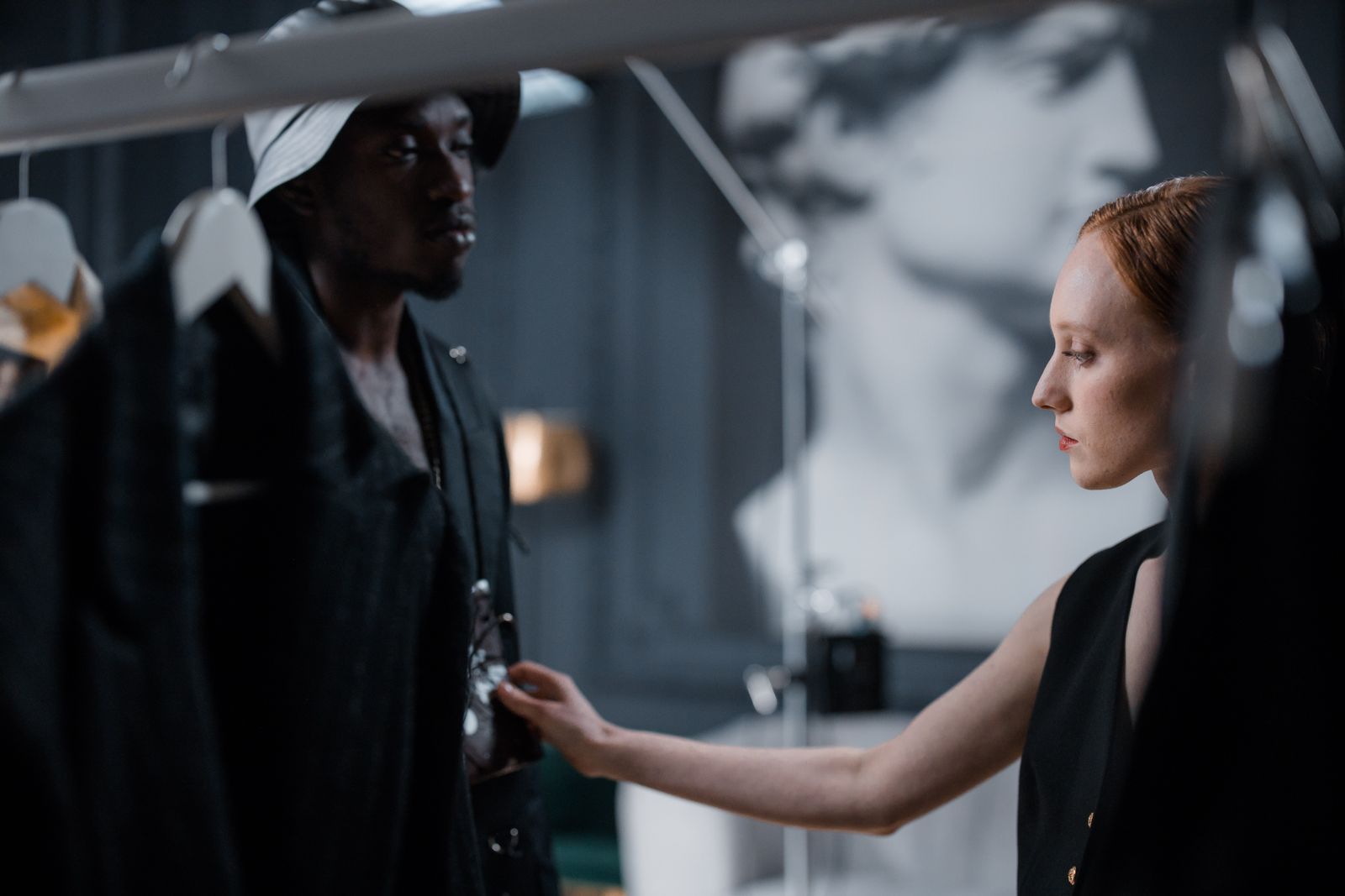 Fashion designer adjusting a garment on a model during a fitting