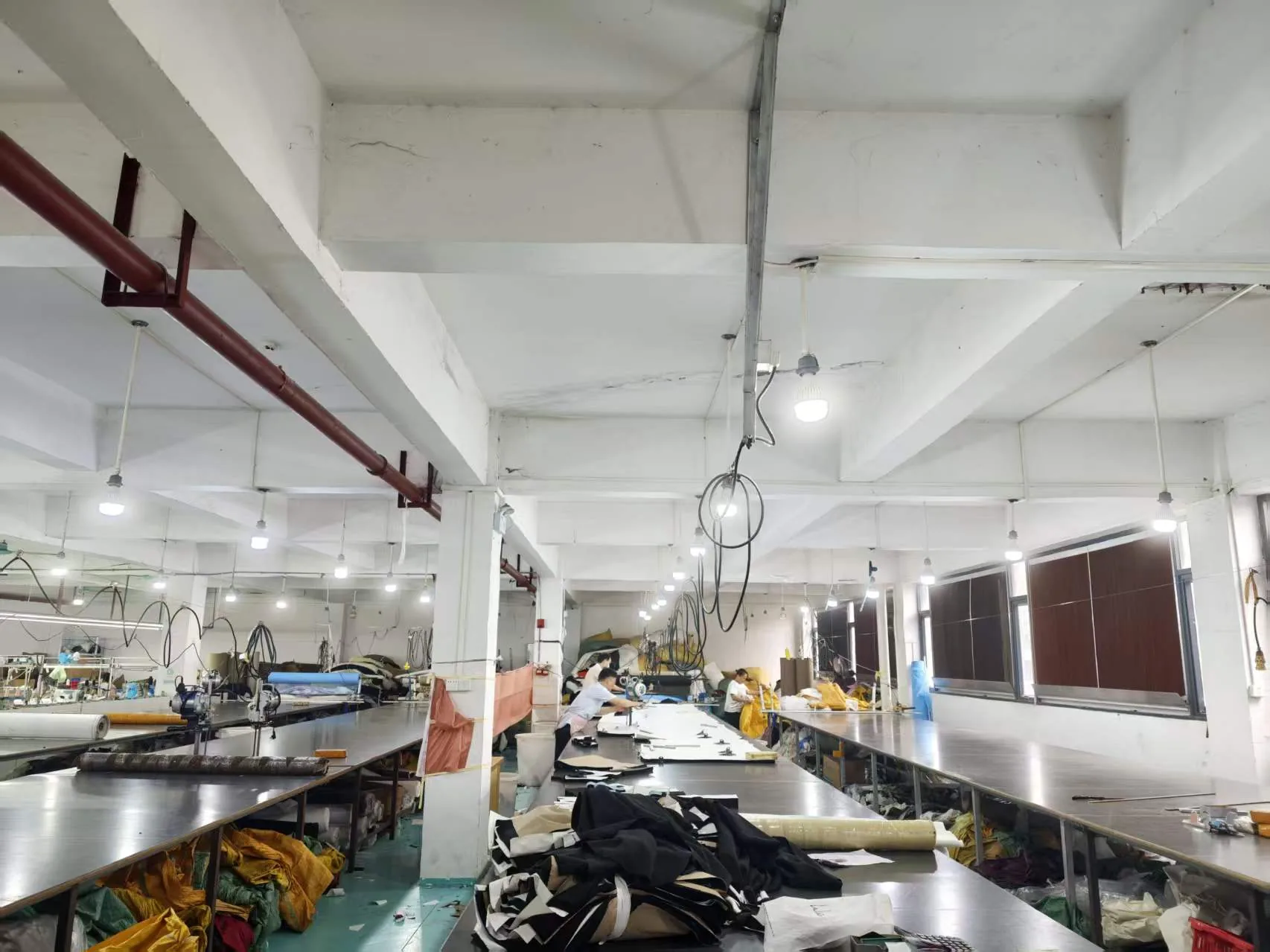Wide view of long cutting tables in the PIPK cutting room